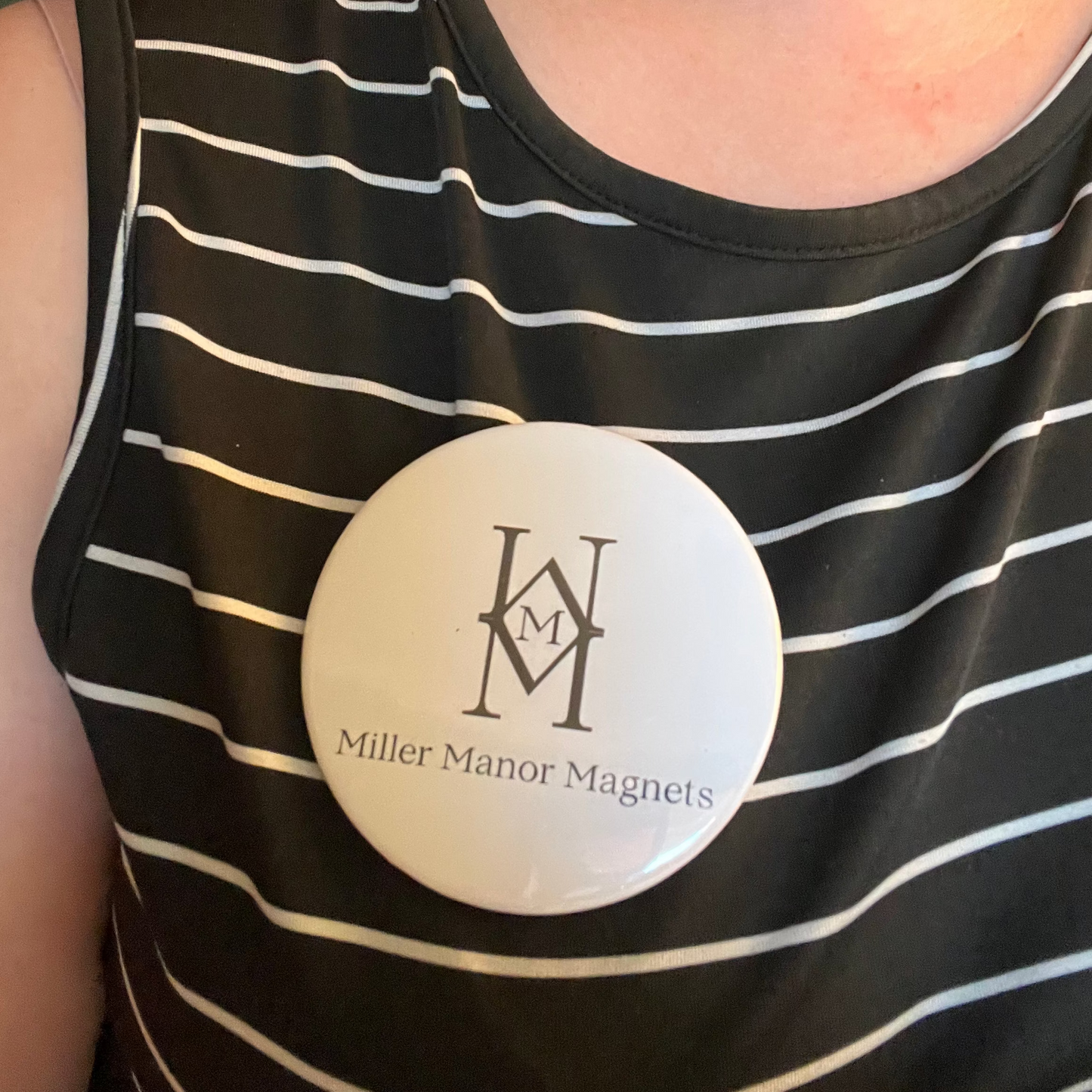 Person wearing a black and white striped tank top with a visible brand logo.