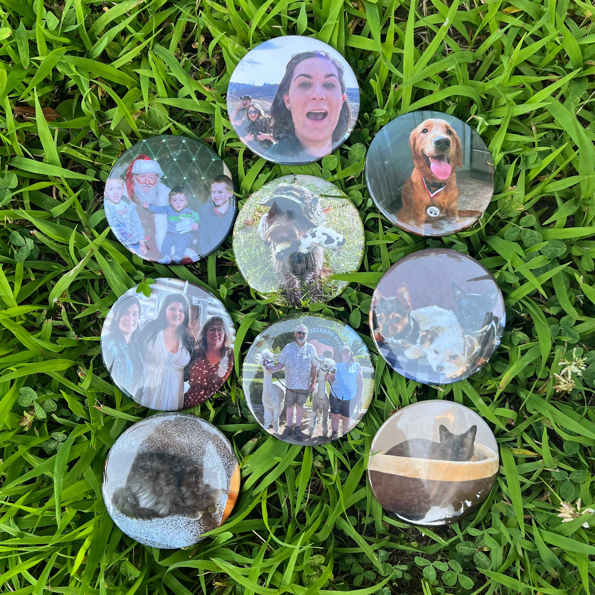 Set of round magnets with various images on them, placed on grass.