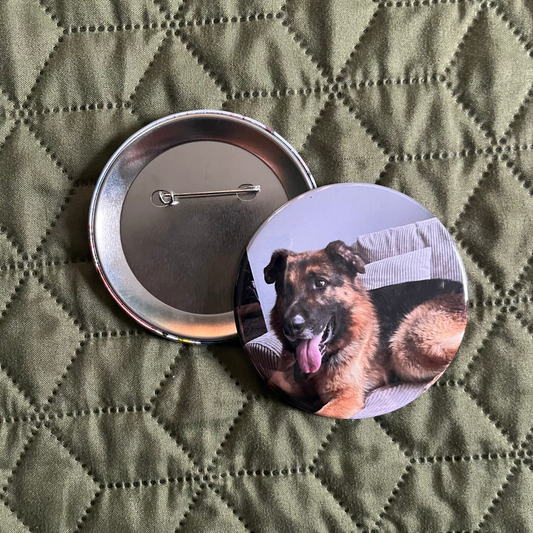 Button badge with a dog design on a green quilted surface