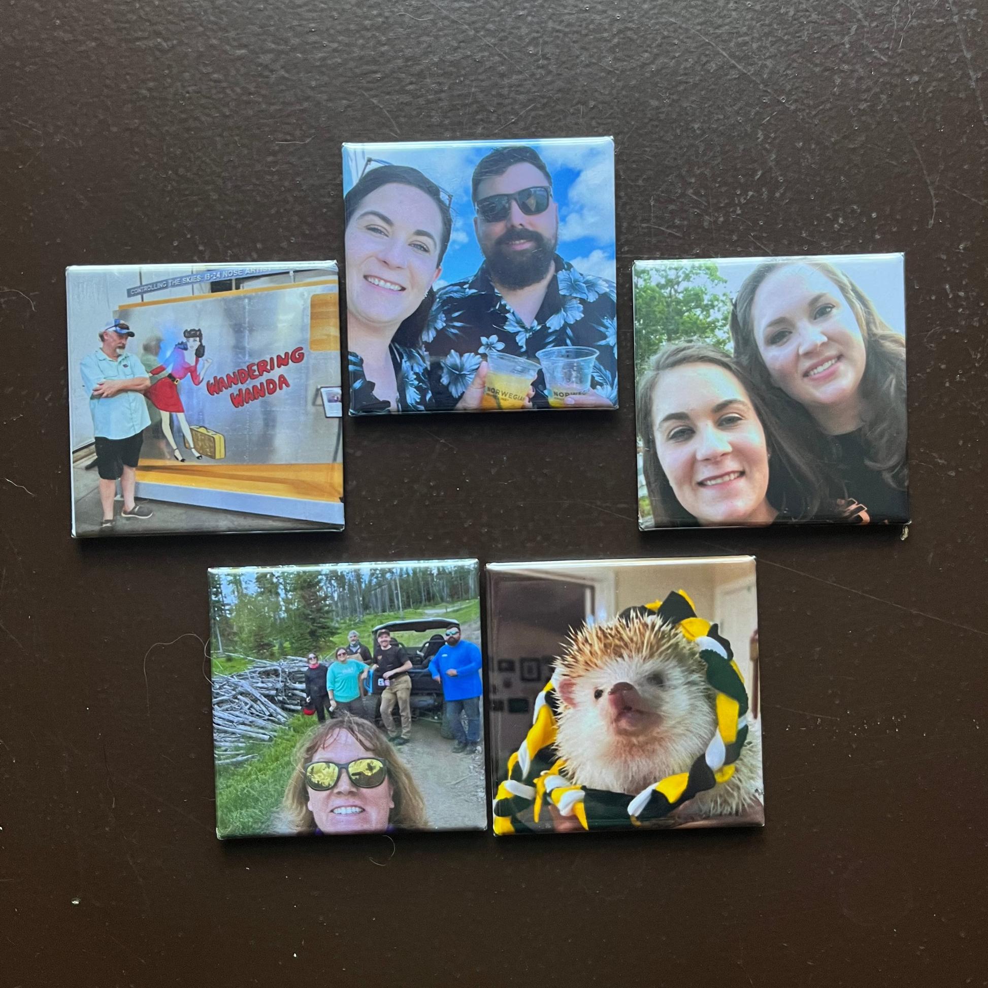 Set of five square magnets with various images on a dark surface