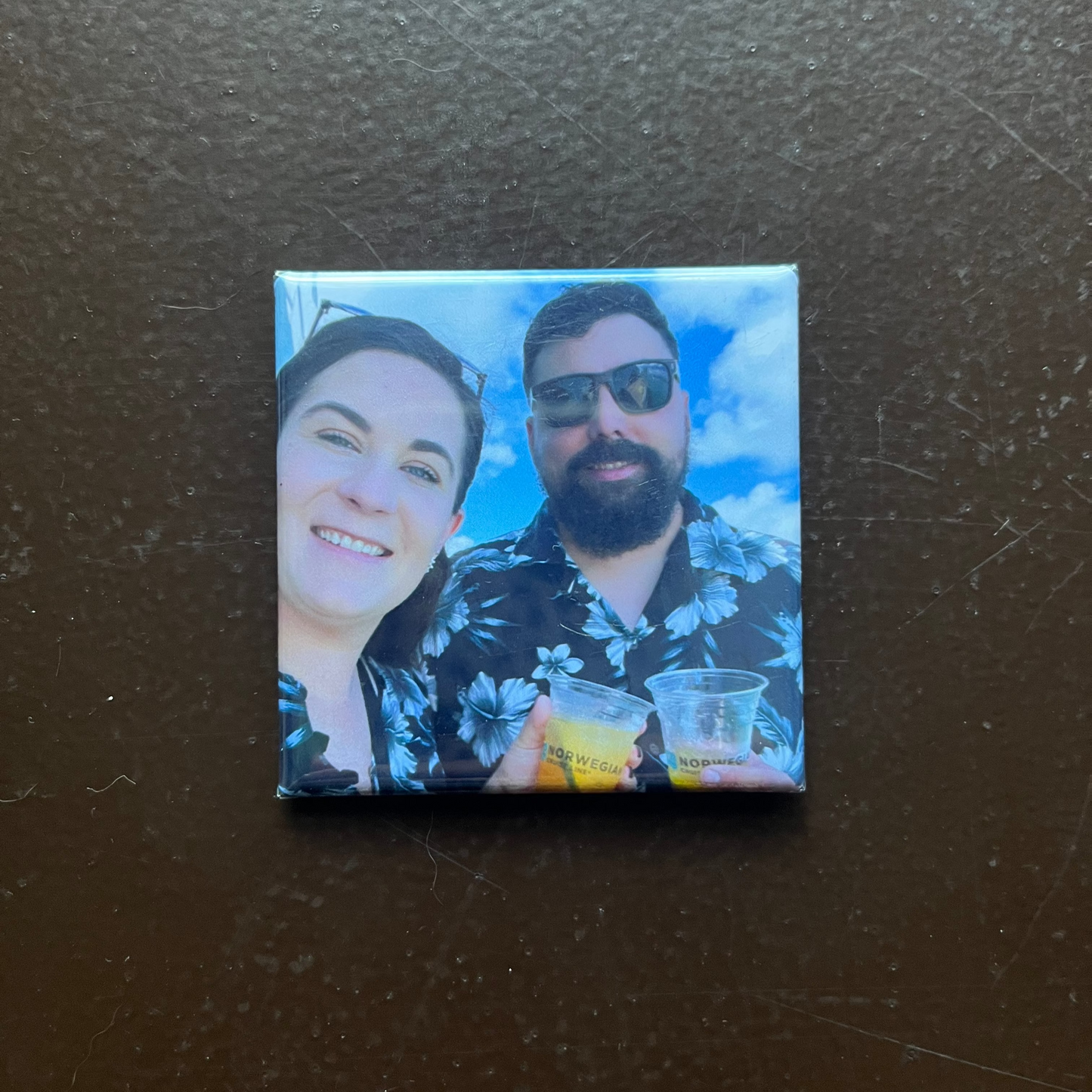 Square magnet with a printed image of two people on a dark surface