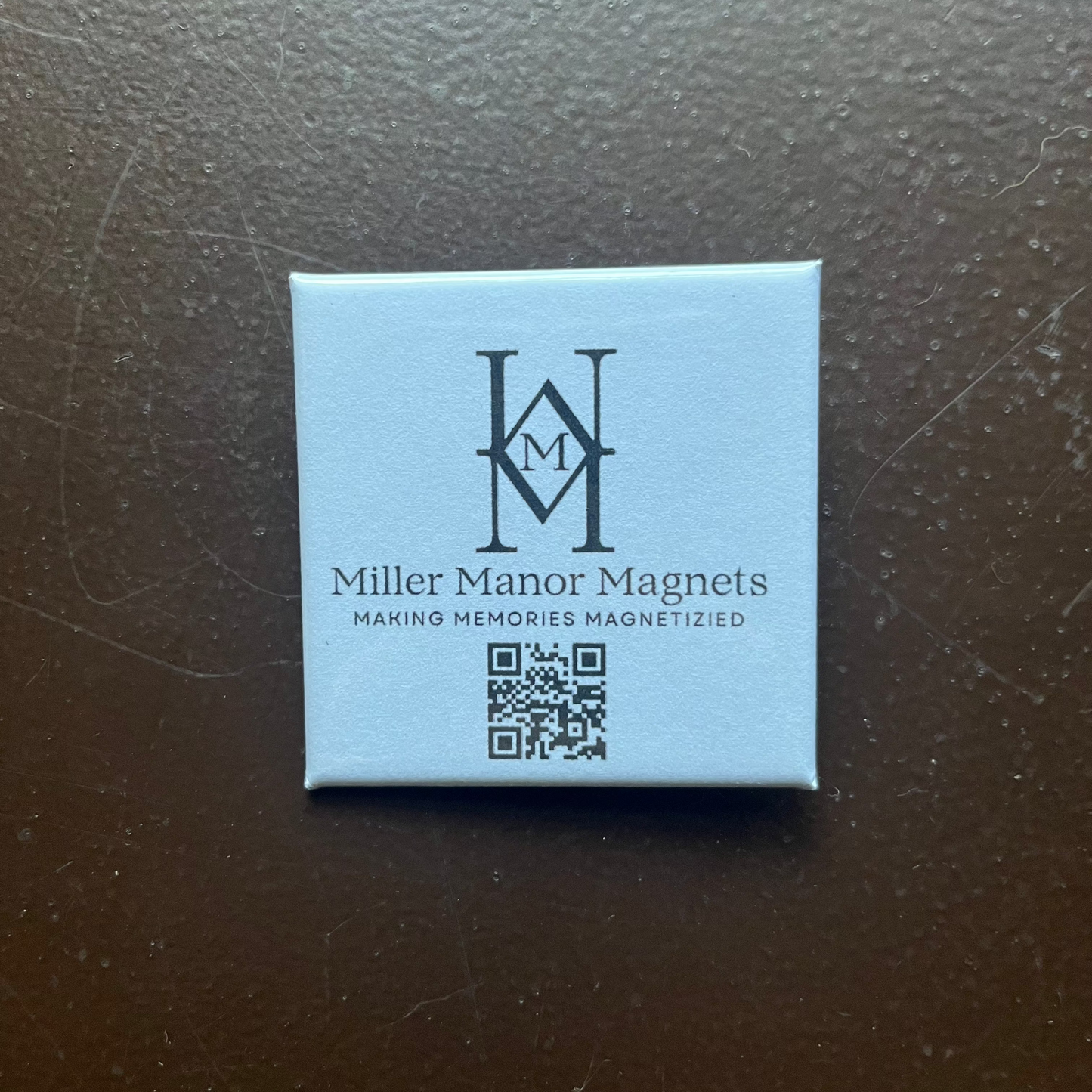 Square magnet with 'Miller Manor Magnets' logo and text on a dark surface