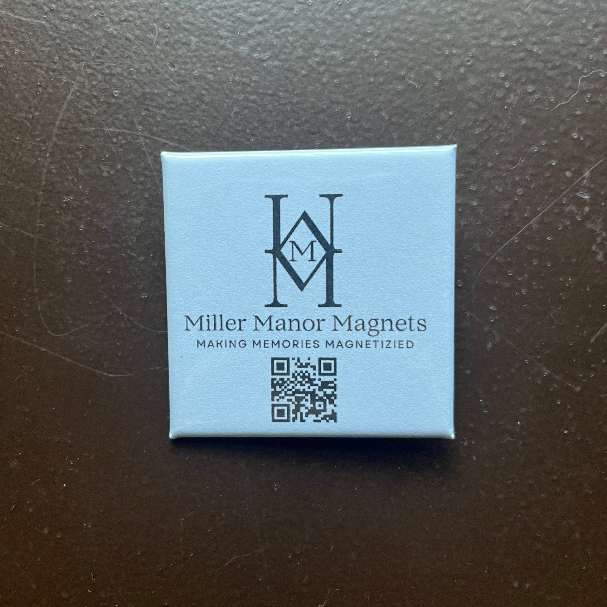 Square magnet with 'Miller Manor Magnets' logo and text on a dark surface